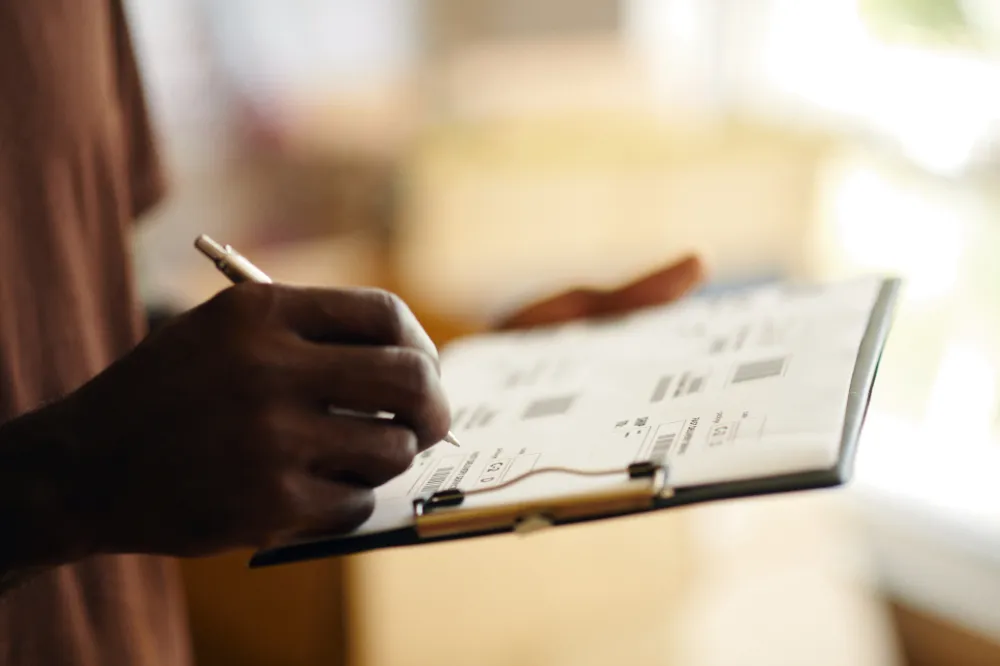closeup of a clipboard with someone filling in details