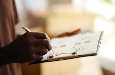 closeup of a clipboard with someone filling in delivery details